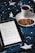 A cozy scene featuring an open ebook reader displaying text, placed on a bed or blanket with a starry pattern. Beside the ebook, there's a white cup filled with a dark beverage, likely coffee or tea, resting on a saucer. Two cookies are placed on the saucer next to the cup.