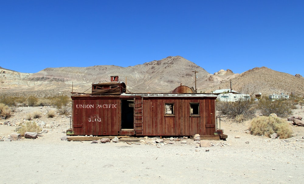 brown wooden house on white sand during daytime