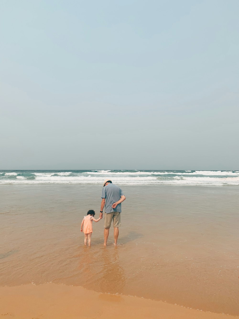 man and woman walking on beach during daytime