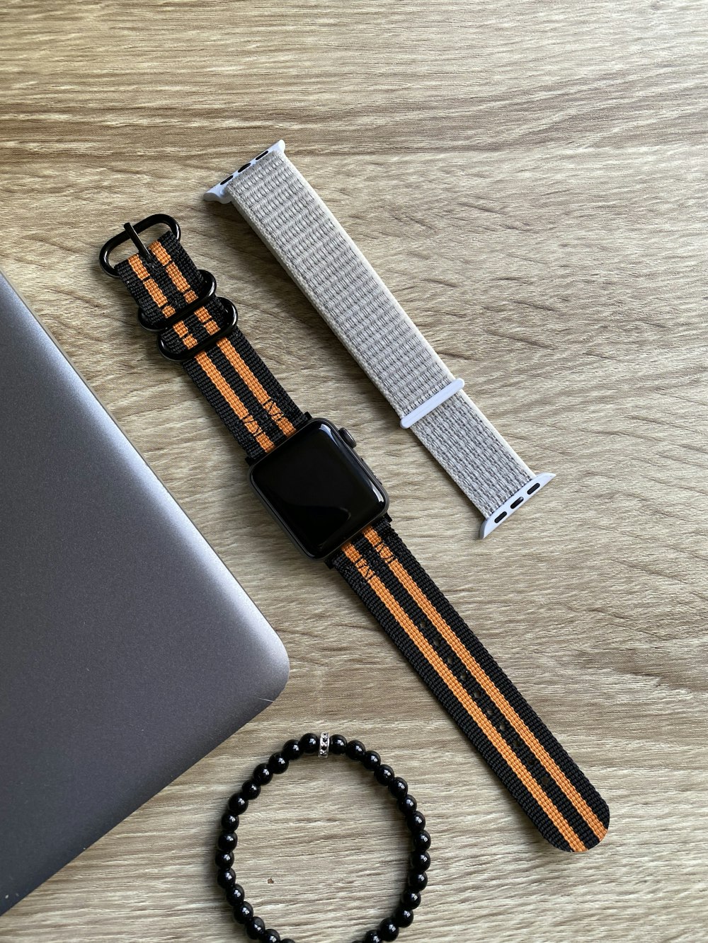 black and silver apple watch with black and gold strap
