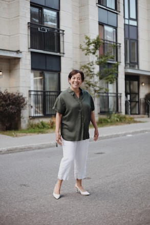 man in green polo shirt and white pants standing on road during daytime
