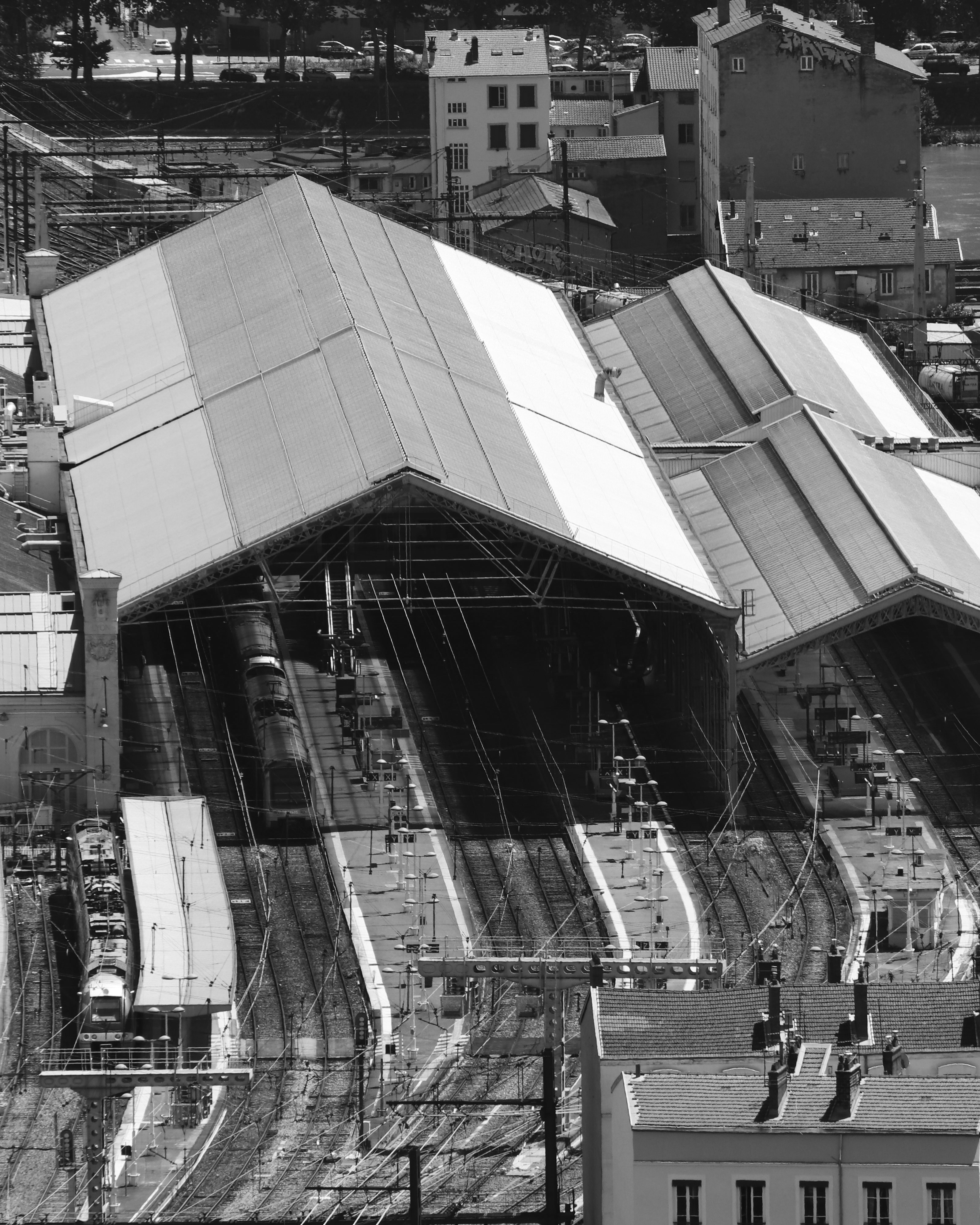 Aerial view of a large train station with multiple rail tracks, platforms and freight trains from above