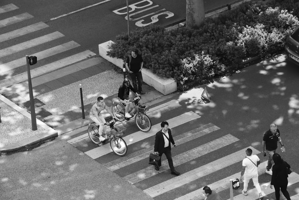 grayscale photo of boy riding bicycle on pedestrian lane