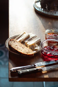 Close-up of artisanal bread and jams on a rustic wooden table