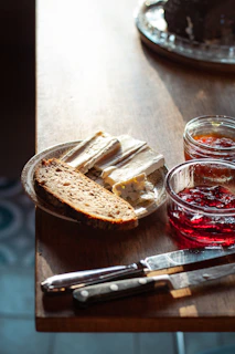 Close-up of artisanal bread and jams on a rustic wooden table