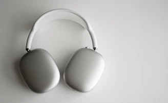 Over-ear headphones with plush cushions and a metal frame on a neutral background.