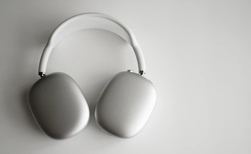 Over-ear headphones with plush cushions and a metal frame on a neutral background.