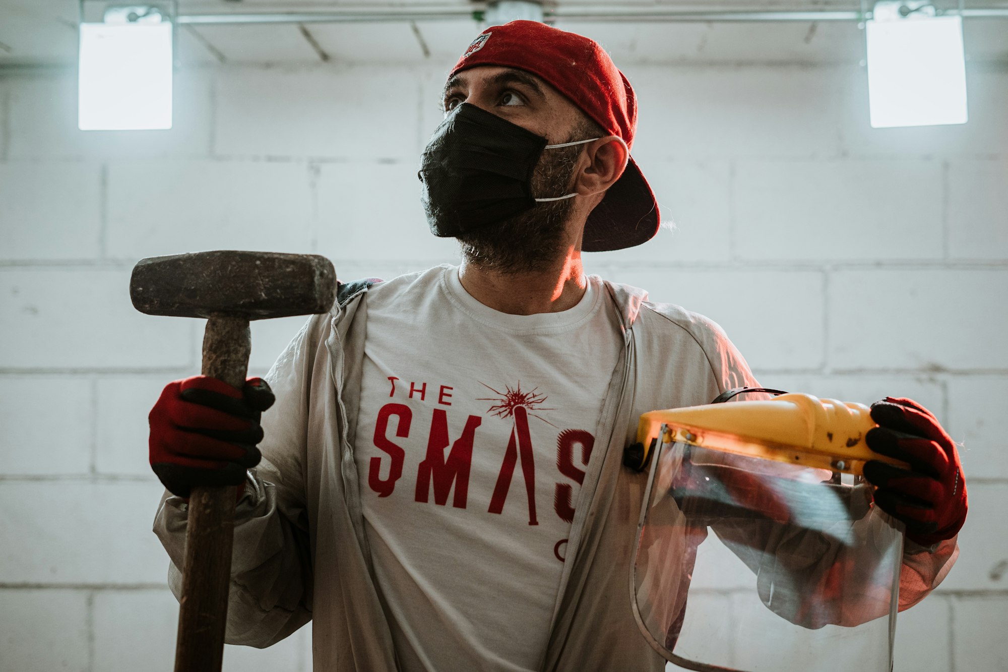 Man holding a sledge hammer and face mask - wornbee.com