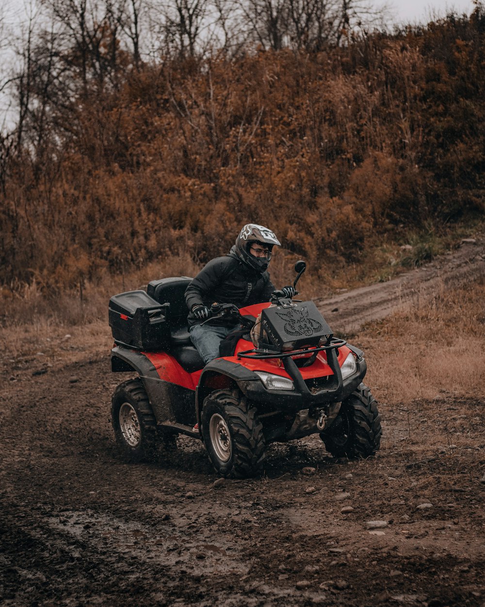 man riding atv on dirt road during daytime