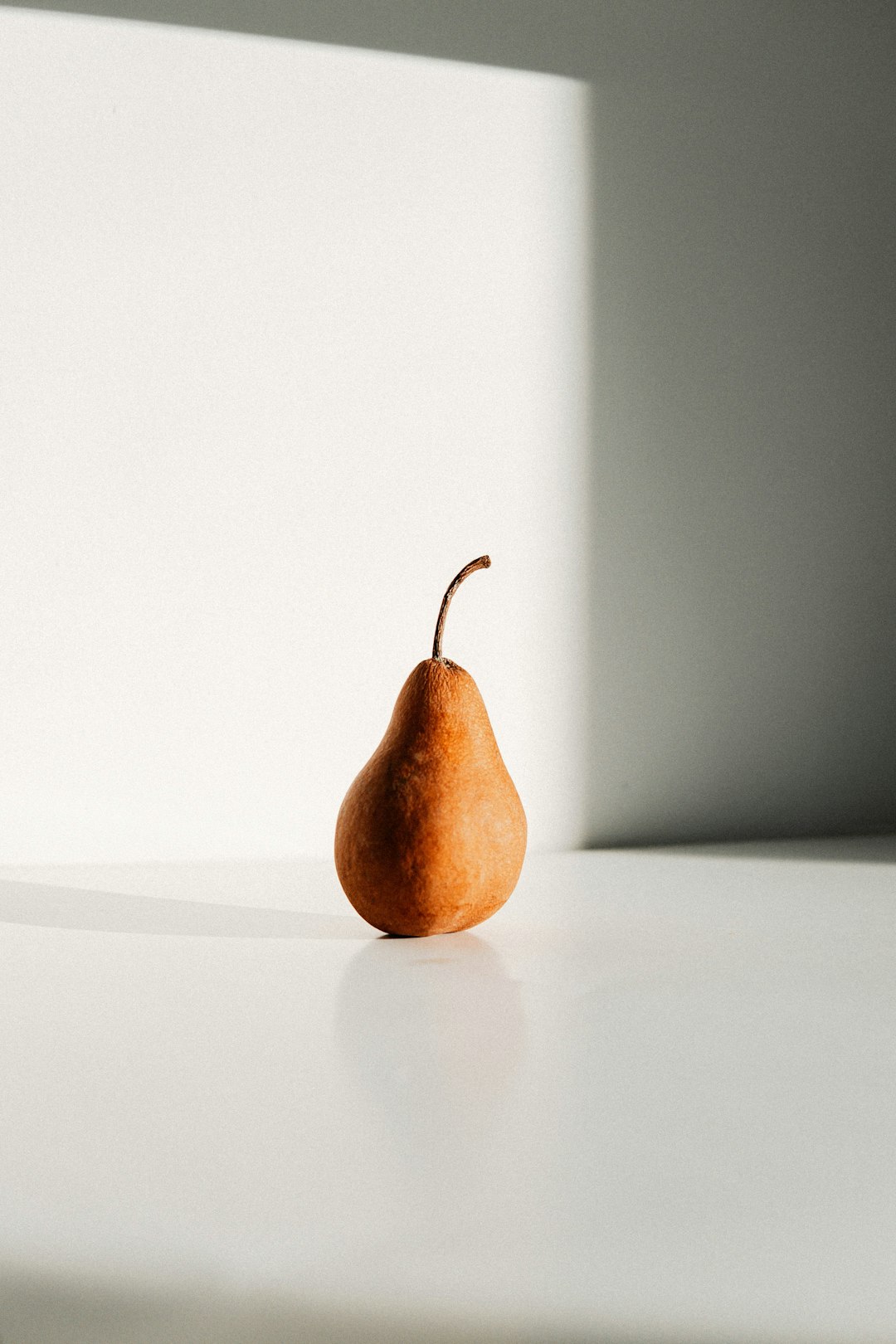 brown apple on white table