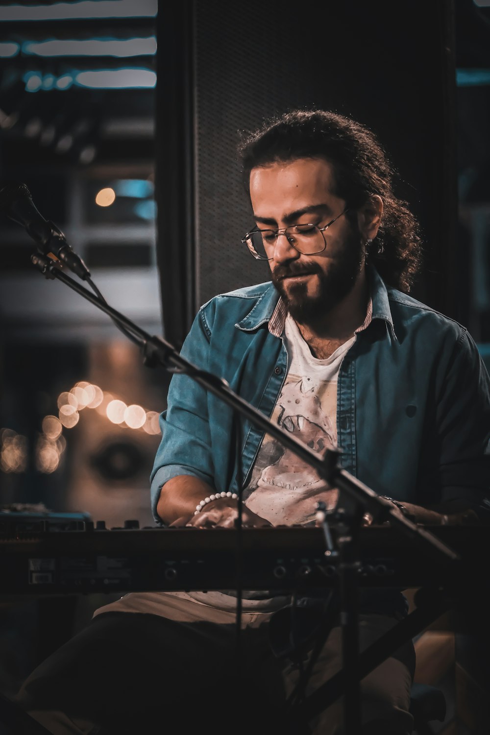 man in blue button up shirt playing piano