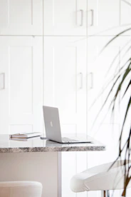silver macbook on white table