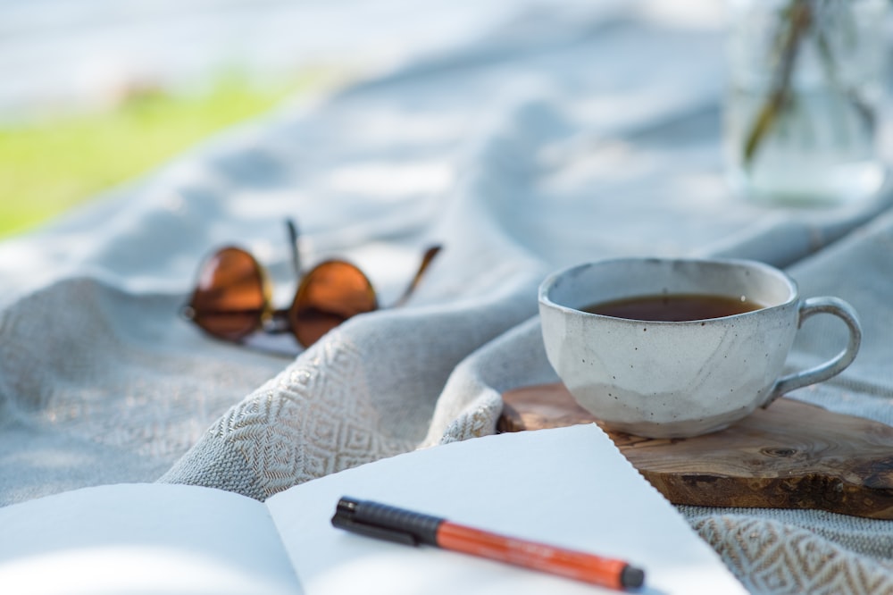 white ceramic cup on white textile