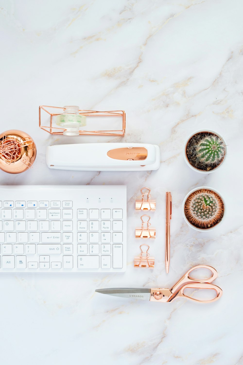 white apple keyboard beside white and green ceramic mug