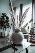 A luxurious cement vase with dried pampas grass in a cozy living room corner.