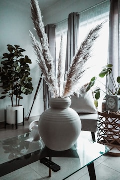 A luxurious cement vase with dried pampas grass in a cozy living room corner.