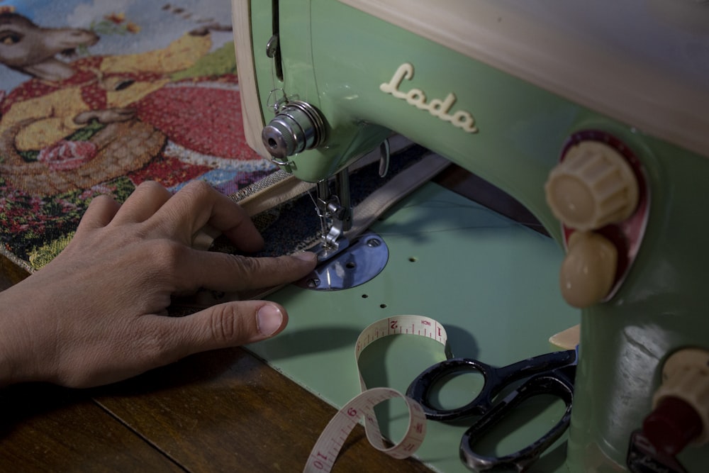 uma pessoa usando uma máquina de costura para costurar em tecido