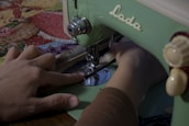 Artisan sewing a Harris Tweed fabric on a vintage sewing machine.