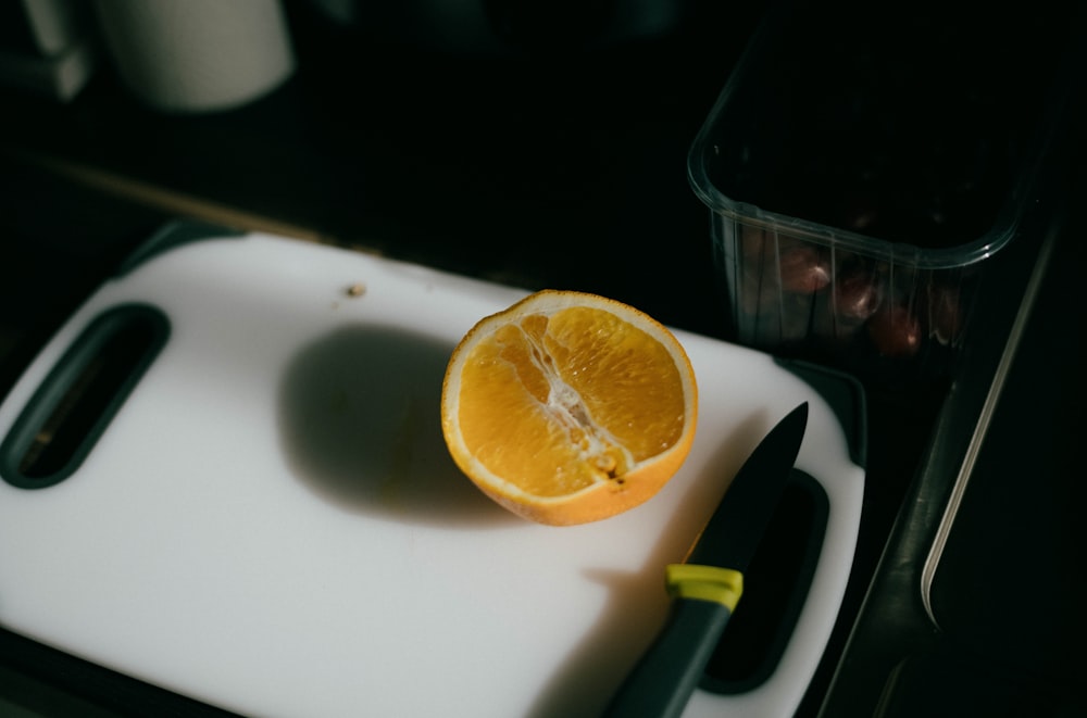 sliced orange fruit on white chopping board