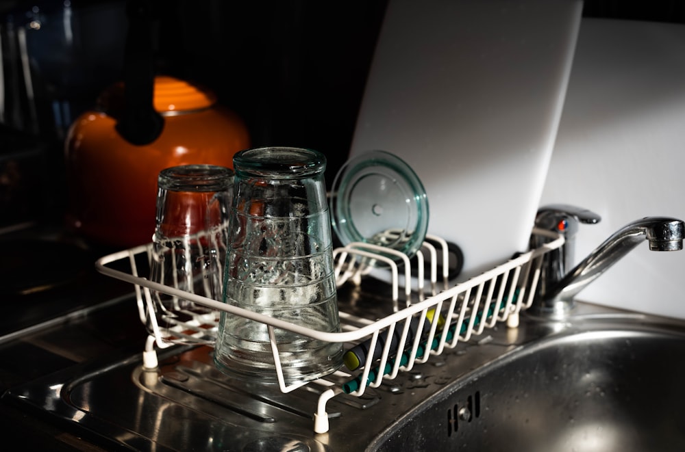 clear glass mugs on white metal rack