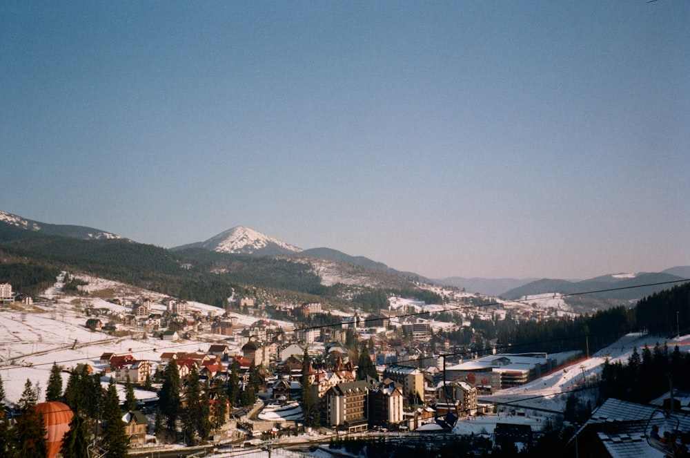 Stadt mit Hochhäusern in der Nähe von Bergen unter blauem Himmel tagsüber