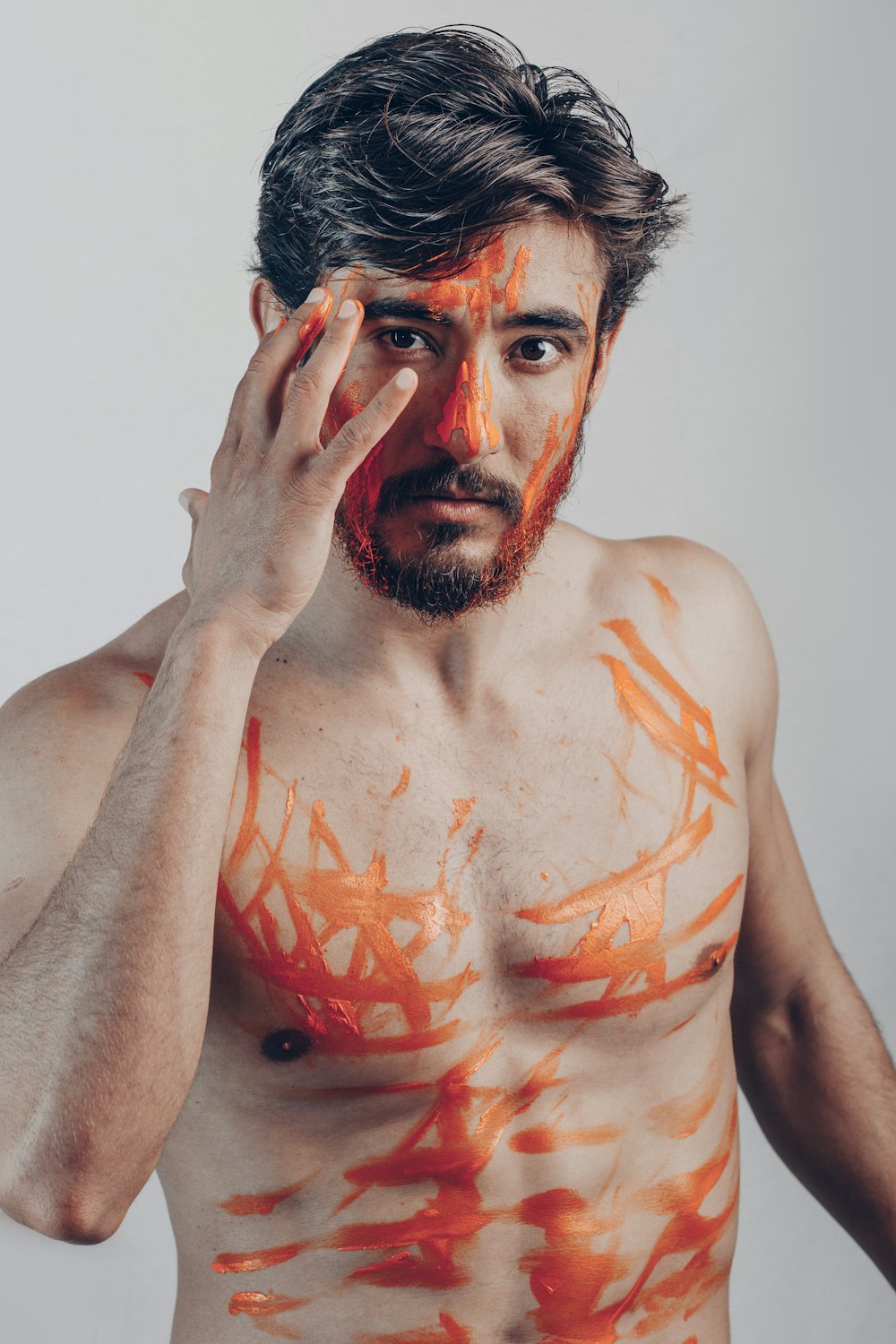 topless man with orange paint on face