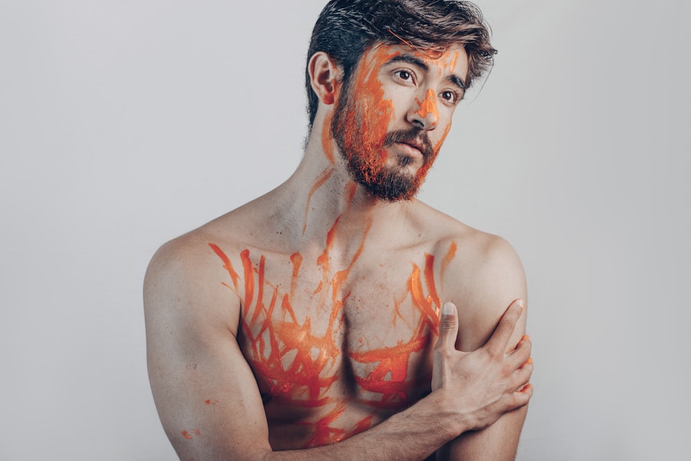 topless man with red paint on his face
