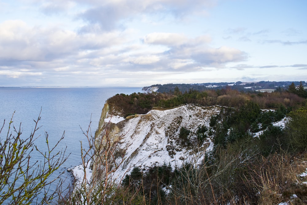 white and brown rock formation near body of water during daytime