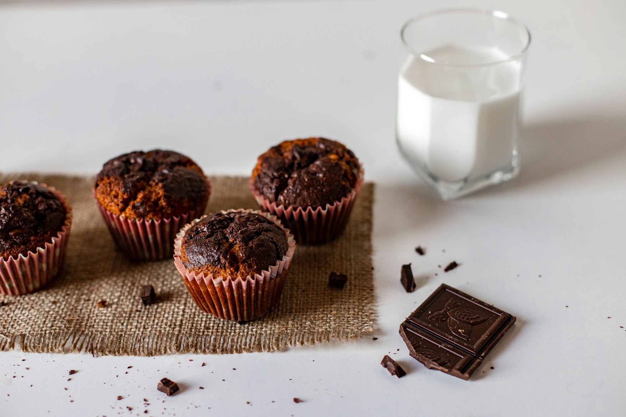 Oven-fresh chocolate cupcakes served with milk and a chocolate bar