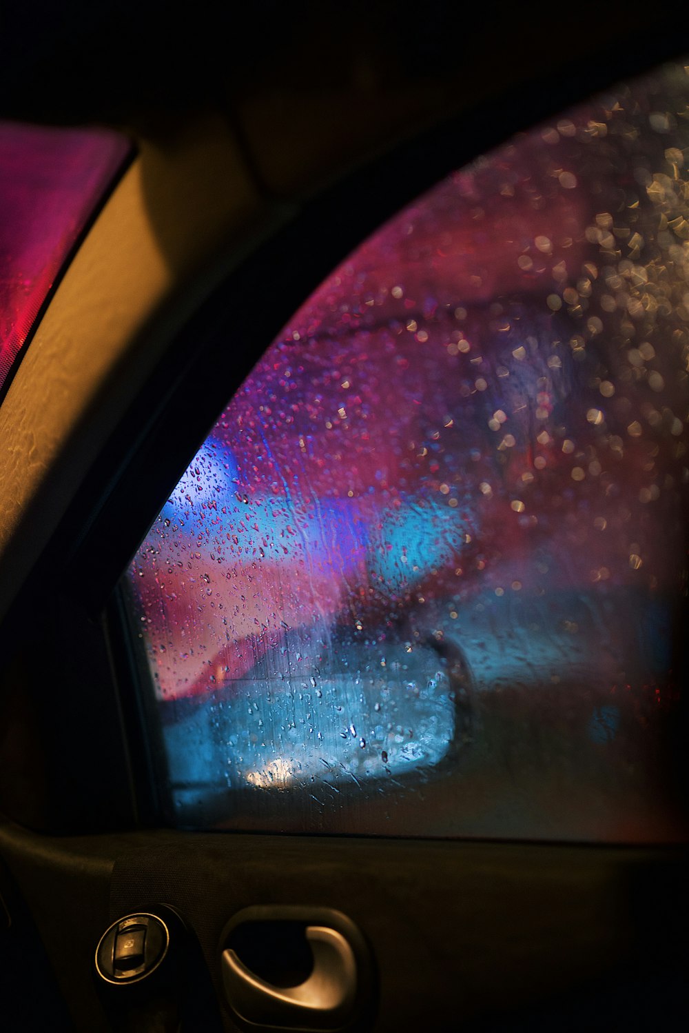 black framed glass window with water droplets