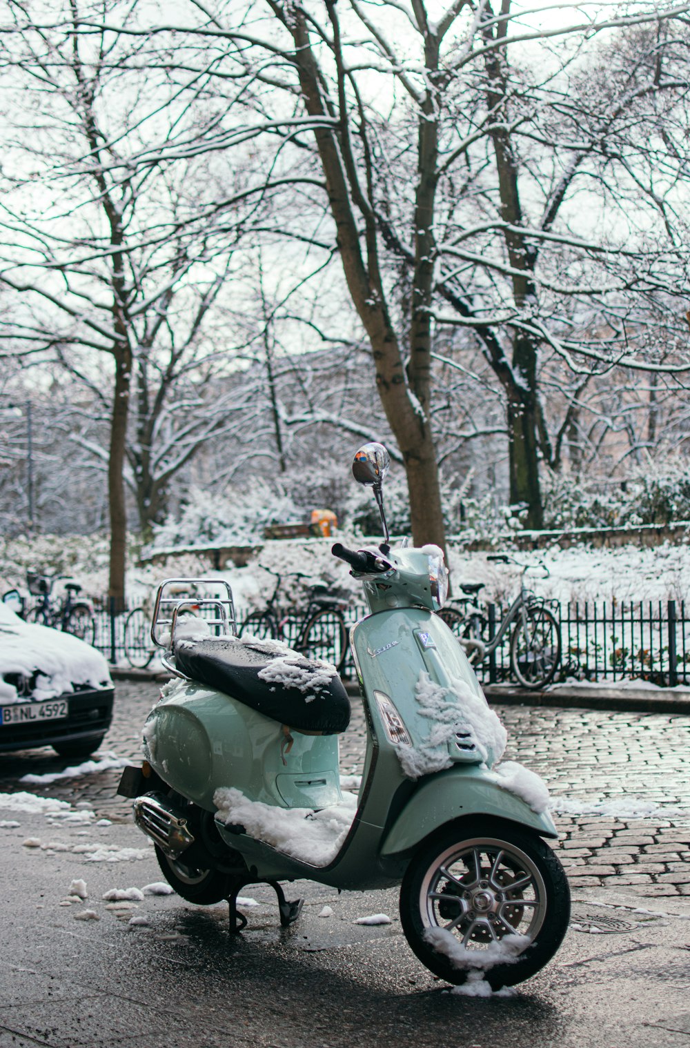Schwarz-weißer Motorroller tagsüber auf schneebedecktem Boden geparkt