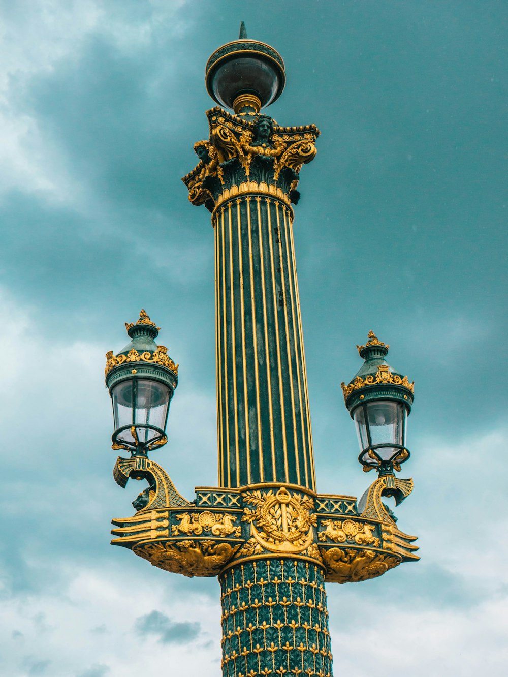 gold and black tower under cloudy sky