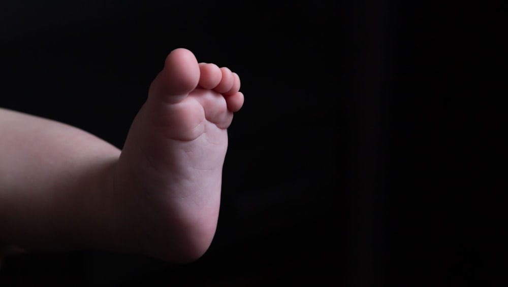 personnes tenant la main du pied de bébé