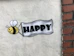 a sign that says happy with a bee on it