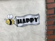 a sign that says happy with a bee on it