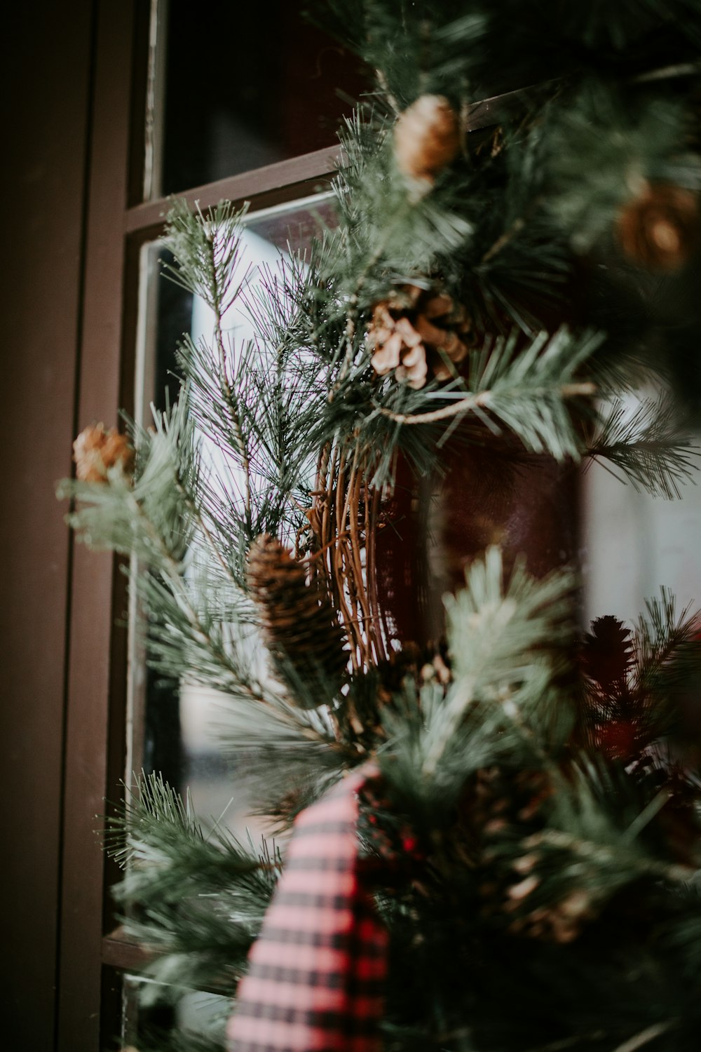 a close up of a christmas wreath on a window sill