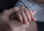 persons hand on top of blue textile
