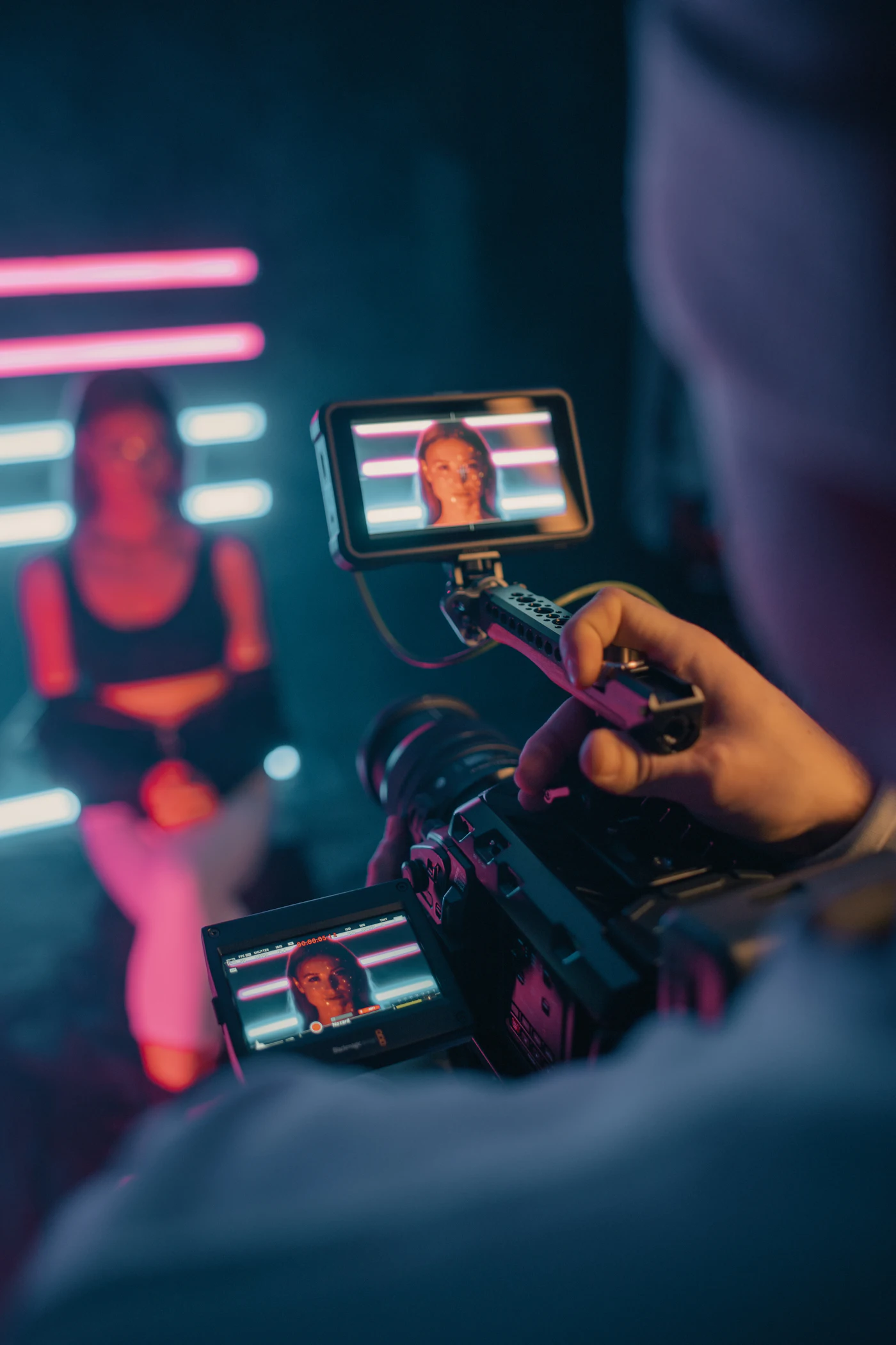 Smartphone filming a person under neon lights