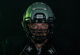 green and black helmet on black textile
