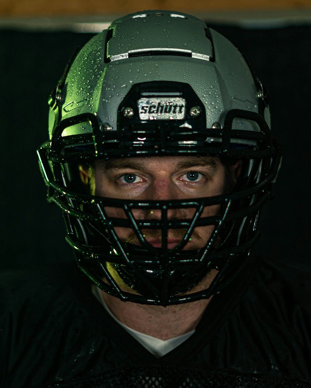 green and black helmet on black textile