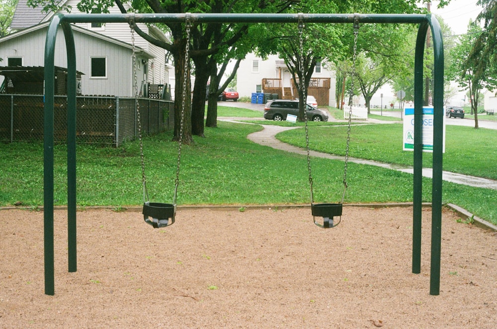 black metal swing on green grass field