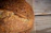 Close-up of a crusty sourdough loaf resting on a wooden board beneath soft natural light.