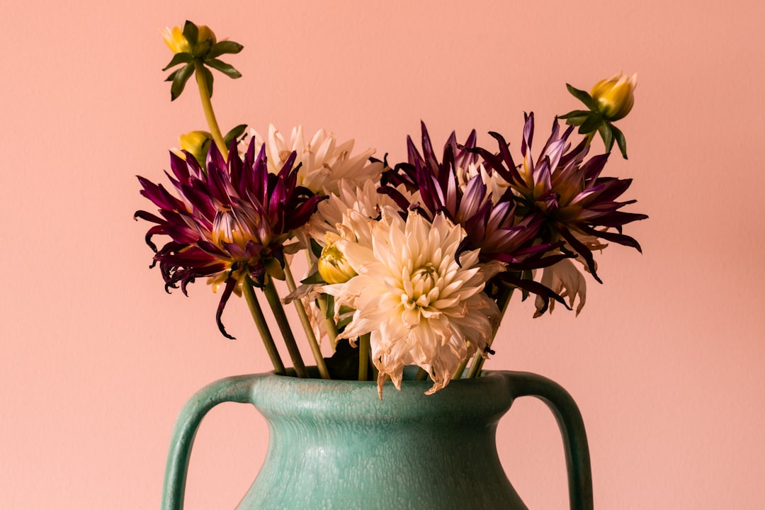 yellow and purple flowers in gray ceramic vase