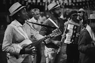 grayscale photo of man playing guitar