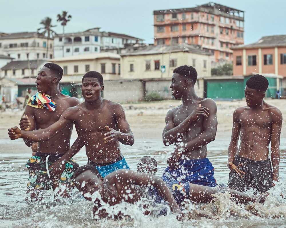 3 boys playing on water during daytime