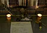 A delicate silver veil adorned with tiny stars draped over an antique writing desk beside a quill and ink.