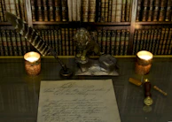 A delicate silver veil adorned with tiny stars draped over an antique writing desk beside a quill and ink.