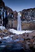 A panoramic shot of a peaceful Icelandic waterfall cascading down rocks.