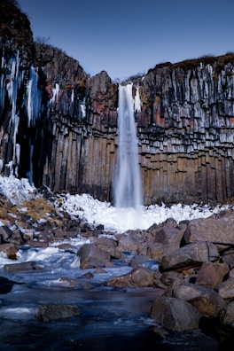 A panoramic shot of a peaceful Icelandic waterfall cascading down rocks.