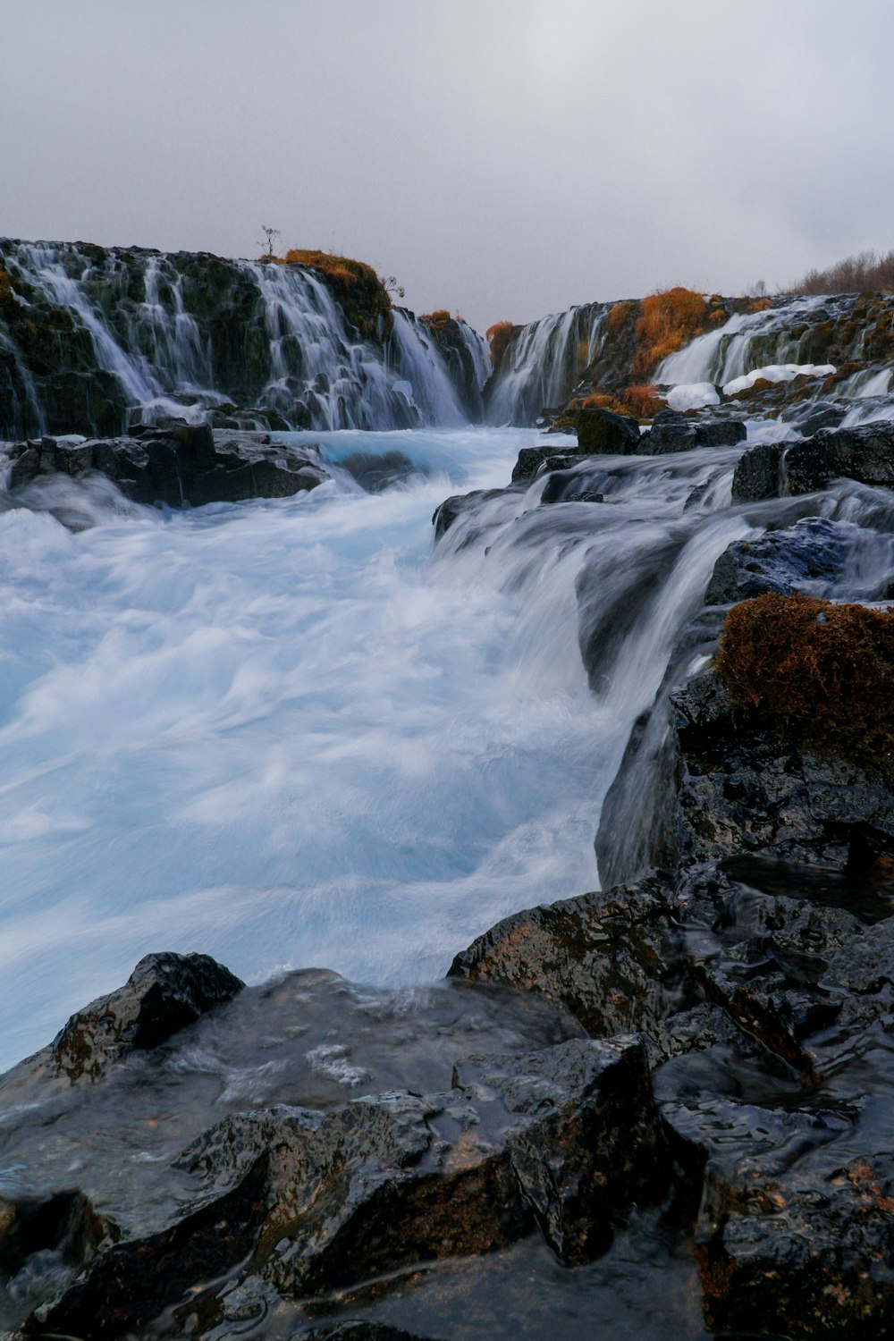 water falls on rocky mountain during daytime